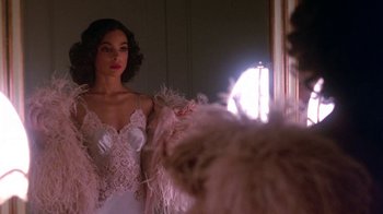 Movie still from “Harlem Nights” (1989), directed by Eddie Murphy – A woman in a white dress is in front of a mirror; Medium shot, Over the shoulder angle