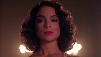 Movie still from “Harlem Nights” (1989), directed by Eddie Murphy – A person with curly brown hair; Close Up shot, Low angle