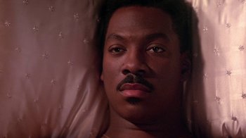 Movie still from “Harlem Nights” (1989), directed by Eddie Murphy – A person laying in a bed; Close Up shot, High angle