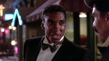 Movie still from “Harlem Nights” (1989), directed by Eddie Murphy – A person wearing a suit and a bow tie; Close Up shot, Low angle