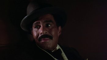 Movie still from “Harlem Nights” (1989), directed by Eddie Murphy – A person wearing a suit and a hat; Close Up shot, Low angle