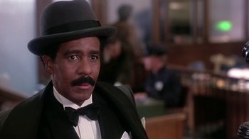 Movie still from “Harlem Nights” (1989), directed by Eddie Murphy – A person wearing a suit and hat; Close Up shot, Low angle