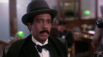 Movie still from “Harlem Nights” (1989), directed by Eddie Murphy – A person wearing a suit and a hat; Close Up shot, Low angle