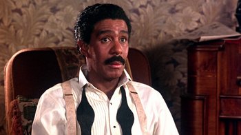 Movie still from “Harlem Nights” (1989), directed by Eddie Murphy – A man in a white shirt and black neck tie; Close Up shot, High angle