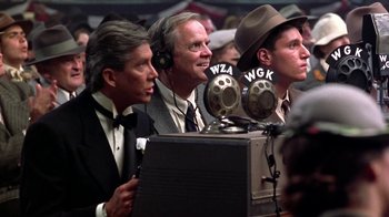Movie still from “Harlem Nights” (1989), directed by Eddie Murphy – A group of men sitting in front of microphones; Close Up shot, Low angle