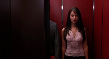 Movie still from “Harold & Kumar Go to White Castle” (2004), directed by Danny Leiner – A woman standing in front of a mirror in an elevator; Medium shot, Low angle