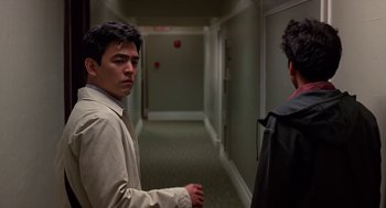 Movie still from “Harold & Kumar Go to White Castle” (2004), directed by Danny Leiner – A man in a tan jacket standing next to another man in a tan jacket; Medium shot, Over the shoulder angle