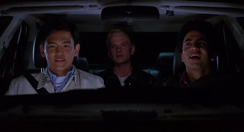 Movie still from “Harold & Kumar Go to White Castle” (2004), directed by Danny Leiner – A group of people sitting in a car at night; Medium shot, Low angle
