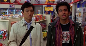 Movie still from “Harold & Kumar Go to White Castle” (2004), directed by Danny Leiner – Two men standing next to each other in a convenience store; Medium shot, Over the shoulder angle