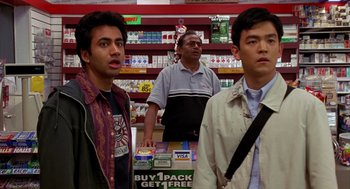 Movie still from “Harold & Kumar Go to White Castle” (2004), directed by Danny Leiner – Two men standing next to each other in a store; Medium shot, Over the shoulder angle