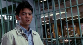 Movie still from “Harold & Kumar Go to White Castle” (2004), directed by Danny Leiner – A man standing in front of a metal fence; Close Up shot, High angle