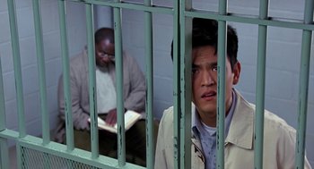 Movie still from “Harold & Kumar Go to White Castle” (2004), directed by Danny Leiner – Two men are in a jail cell looking through the bars; Medium shot, Over the shoulder angle