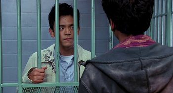Movie still from “Harold & Kumar Go to White Castle” (2004), directed by Danny Leiner – A man standing in front of another man behind bars; Medium shot, Over the shoulder angle