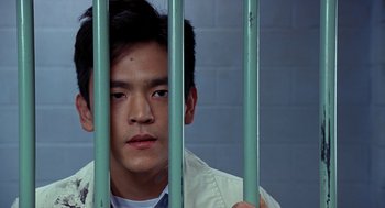 Movie still from “Harold & Kumar Go to White Castle” (2004), directed by Danny Leiner – A man behind a metal fence looking at the camera; Close Up shot, High angle
