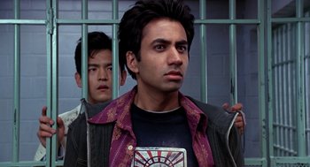 Movie still from “Harold & Kumar Go to White Castle” (2004), directed by Danny Leiner – A man standing next to another man behind a fence; Close Up shot, Low angle