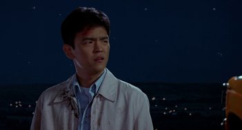 Movie still from “Harold & Kumar Go to White Castle” (2004), directed by Danny Leiner – A man in a white shirt is standing in front of a night sky; Close Up shot, Low angle