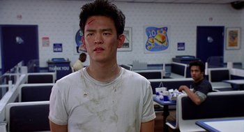 Movie still from “Harold & Kumar Go to White Castle” (2004), directed by Danny Leiner – A young man in a white t - shirt with blood all over his face; Close Up shot, Over the shoulder angle