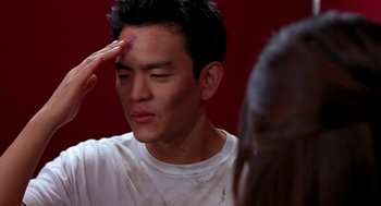 Movie still from “Harold & Kumar Go to White Castle” (2004), directed by Danny Leiner – A young man is getting his forehead touched by an older woman; Close Up shot, Over the shoulder angle