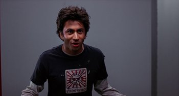 Movie still from “Harold & Kumar Go to White Castle” (2004), directed by Danny Leiner – A man in a t - shirt is looking at the camera; Close Up shot, Low angle